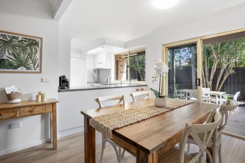 a kitchen and dining room with a wooden table and chairs at Lennox Belle in Lennox Head