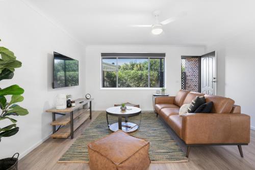 a living room with a couch and a table at Lennox Belle in Lennox Head