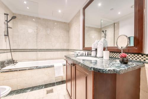 a bathroom with a tub and a sink at Stella Stays Ultimate 4 BR Penthouse Private Pool Panoramic View in Dubai