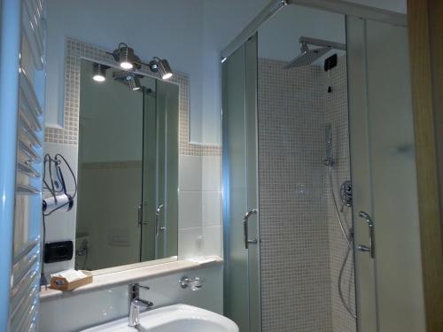 a bathroom with a sink and a shower with a mirror at B&B Casa Venezia in Bernalda