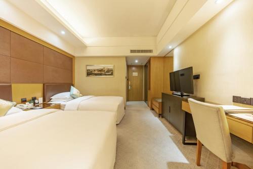 a hotel room with two beds and a desk at Aurum International Hotel Xi'an in Xi'an