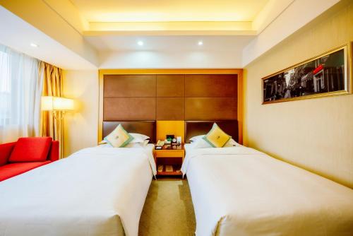 a hotel room with two beds and a red couch at Aurum International Hotel Xi'an in Xi'an