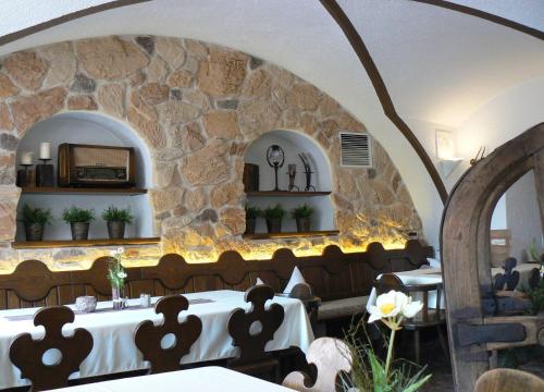 a dining room with a table and a stone wall at Hotel Mayerhofer in Aldersbach