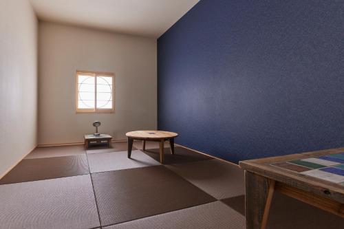 a room with a table and a blue wall at HOTEL tuka miika in Ishigaki Island