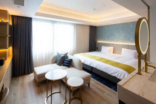 a hotel room with a bed and a couch at Nikko Style Nagoya in Nagoya