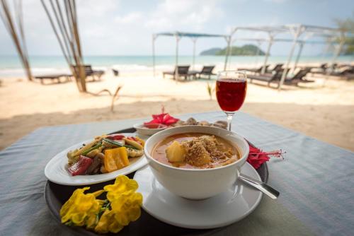 マーク島にあるSabai Beach Resortのスープとワインのグラスを入れたテーブル