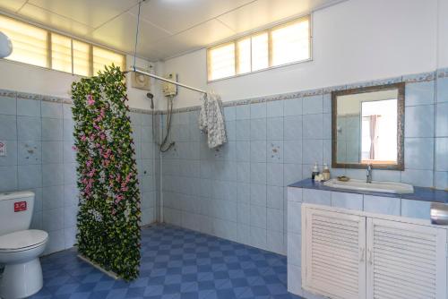 Sabai Beach Resort في كو ماك: حمام مع مرحاض وزرع على الحائط