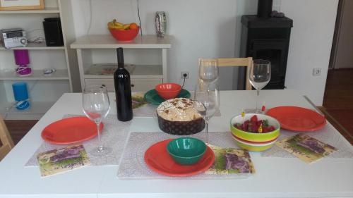 a table with red plates and wine glasses and a cake at Holiday home Pavarotti in Supetar