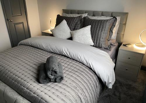 a stuffed animal is laying on a bed at Beautiful modern cosy central apartment / sleeps 4 in Reading