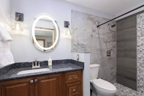 a bathroom with a sink and a toilet and a mirror at Woodbridge 21C in Snowmass Village