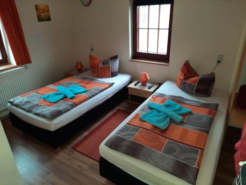 two beds in a room with blue pillows on them at Gasthaus & Pension Zum Göschen in Grimma