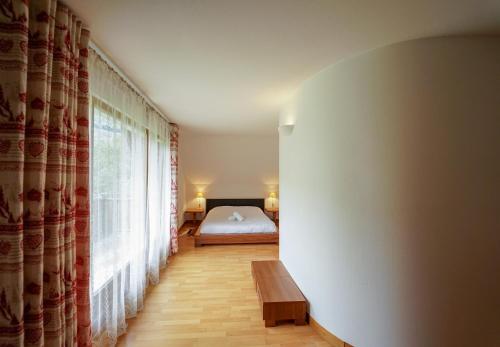 Schlafzimmer mit einem Bett, einem Tisch und einem Fenster in der Unterkunft Vacancéole - Résidence Le Birdie in Giez