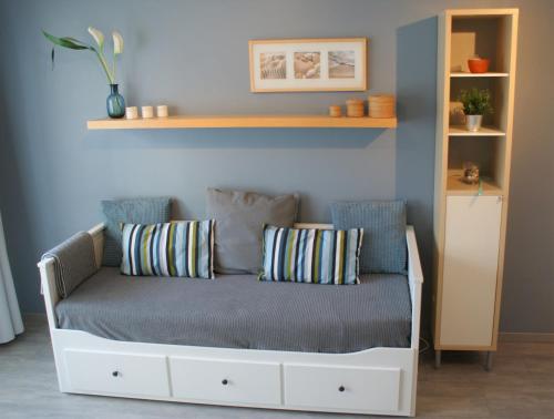 a couch with pillows on it in a room at Sea Side in Ostend