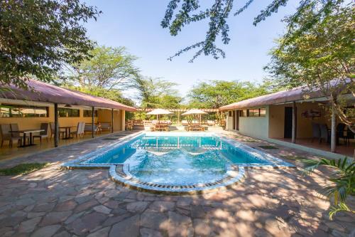 una piscina al centro di una casa di PrideInn Mara Camp & Cottages a Talek