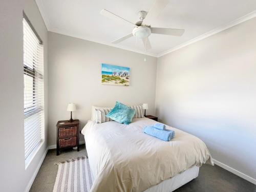 a bedroom with a bed and a ceiling fan at Sunset View at Whale Cove in Gansbaai