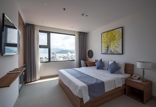 a bedroom with a bed and a large window at Delight Hotel in Quy Nhon