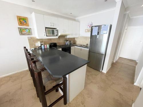 a kitchen with a black counter top and a refrigerator at Sunset View at Whale Cove in Gansbaai