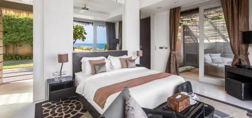 a bedroom with a bed and a view of the ocean at Sangsuri Villa 1 in Choeng Mon Beach