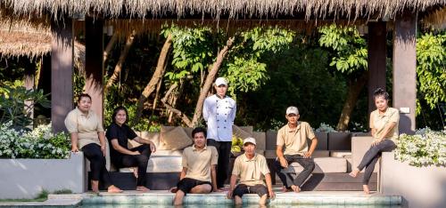 a group of men sitting on a bench next to a pool at Sangsuri Villa 1 in Choeng Mon Beach