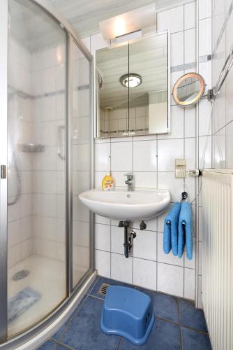 a bathroom with a sink and a shower at Ferienhaus Weiße Robbe in Bensersiel