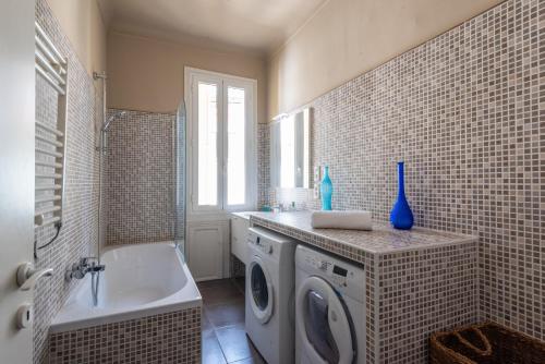 La salle de bains est pourvue d'un lave-linge et d'une baignoire. dans l'établissement Londres, à Nice