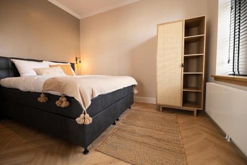 a bedroom with a large bed and a window at Bed en Baguette in Burgh Haamstede