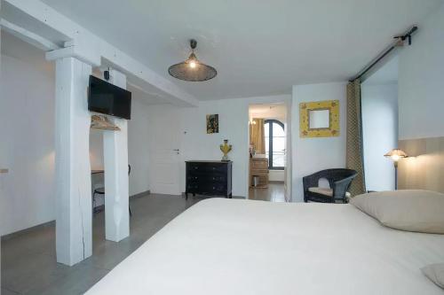 a bedroom with a large white bed and a desk at Ilot du Moulin in Mordelles