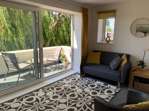 a living room with a couch and a balcony at Balcony Apartment near Skegness Beach & Town in Skegness