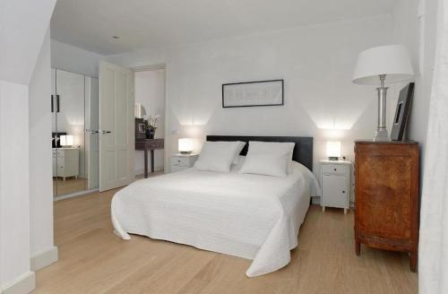 1 dormitorio blanco con 1 cama blanca y 2 lámparas en Luxury Prinsengracht Canal House Jordan Area, en Ámsterdam