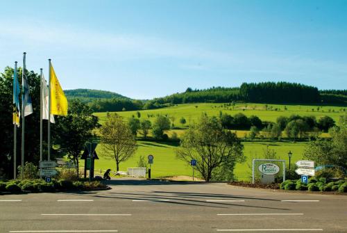 an empty parking lot with a green hill in the background at Romantikhotel Platte in Attendorn