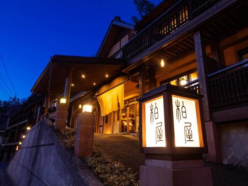 a building with a clock in front of it at night at Shima Onsen Kashiwaya Ryokan in Nakanojo