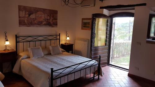 a bedroom with a bed and a large window at Casale sul Lago Trasimeno in San Feliciano