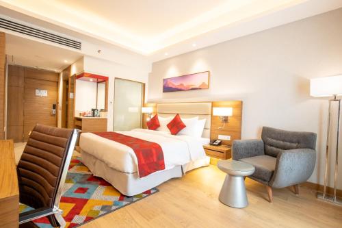 a hotel room with a bed and two chairs at Ramada Encore by Wyndham Kathmandu Thamel in Kathmandu