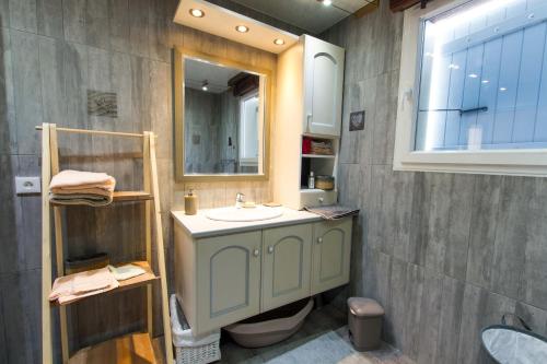 a bathroom with a sink and a mirror at le chalet vendéen in Saint-Hilaire-la-Forêt