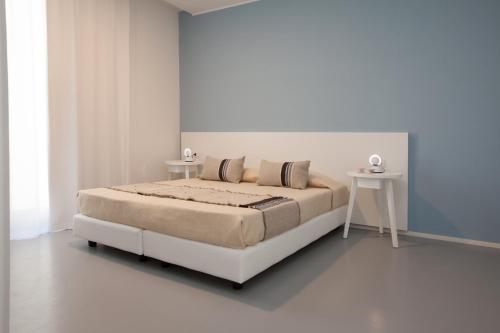 a white bedroom with a bed and a table at Residenza Dante in Nuoro