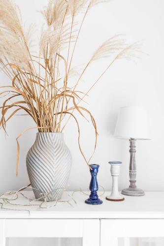 a white table with a vase with a plant in it at Nice Sopot in Sopot