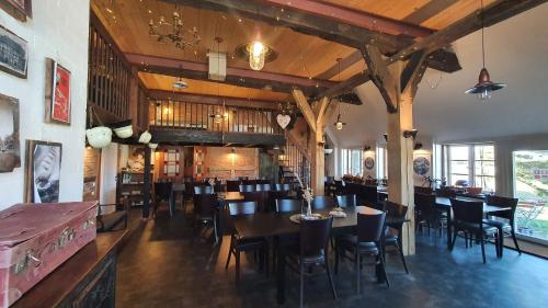 a dining room with tables and chairs in a restaurant at Haus Anna Elbe, Bauernhaus-Ferienwohnungen an der Elbe in Hamburg