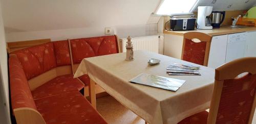 un piccolo tavolo con sedie in una piccola cucina di Ferienwohnung-Floppy-Hansi-OG-3 a Sankt Peter-Ording