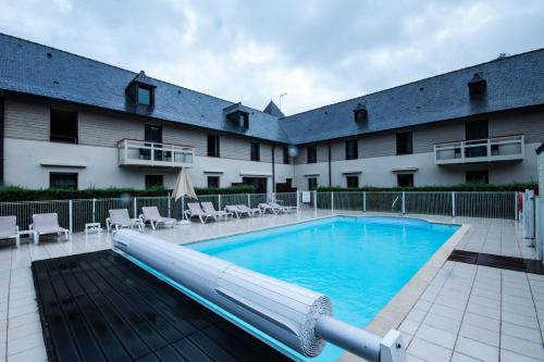 a large swimming pool in front of a building at Mercure Dinan Port Le Jerzual in Dinan