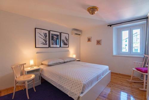 1 dormitorio con 1 cama, 2 sillas y ventana en Apartments and Rooms Ille en Šibenik