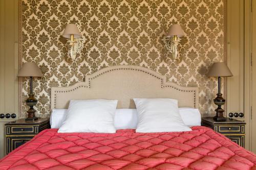 a bedroom with a red bed with two night stands at Chateau LE BROSSAY in Renac