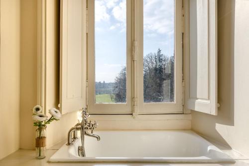 a bath tub in a bathroom with a window at Chateau LE BROSSAY in Renac