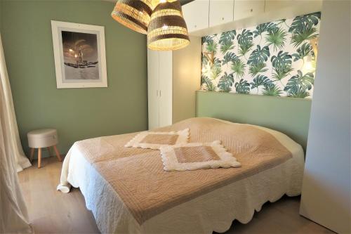 ein Schlafzimmer mit einem Bett und einer grünen Wand in der Unterkunft Port Marine in Sainte-Maxime