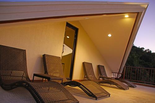 a group of chairs sitting on a balcony at Layang Layang Home in El Nido