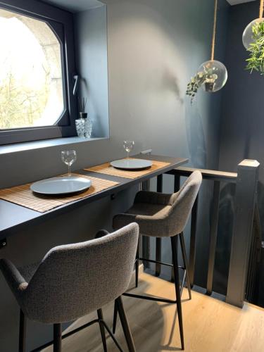 un bar avec deux chaises et une table avec des verres dans l'établissement La Petite Maison 1933, à Vesoul