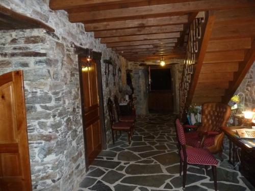 a hallway with chairs and a stone wall at Casa Rural A Pasada in Cedeira