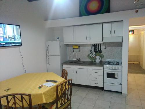 cocina con mesa y nevera blanca en Mendoza Departamento 4 o 5 personas en Mendoza