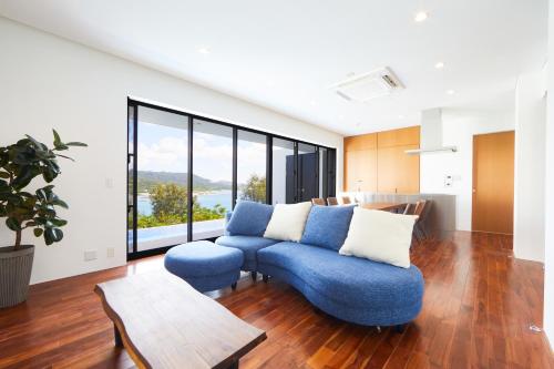 a living room with a blue couch and a table at E-horizon Resort Premium 瀬底D in Motobu