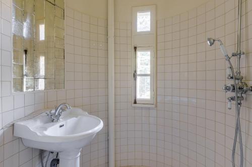 a white bathroom with a sink and a shower at Chateau LE BROSSAY in Renac