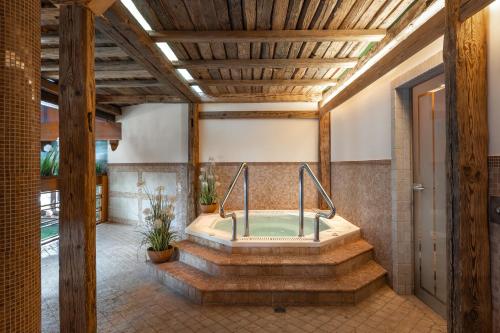 eine Whirlpool-Badewanne in der Mitte eines Zimmers in der Unterkunft Alpejski Boutique Hotel in Karpacz